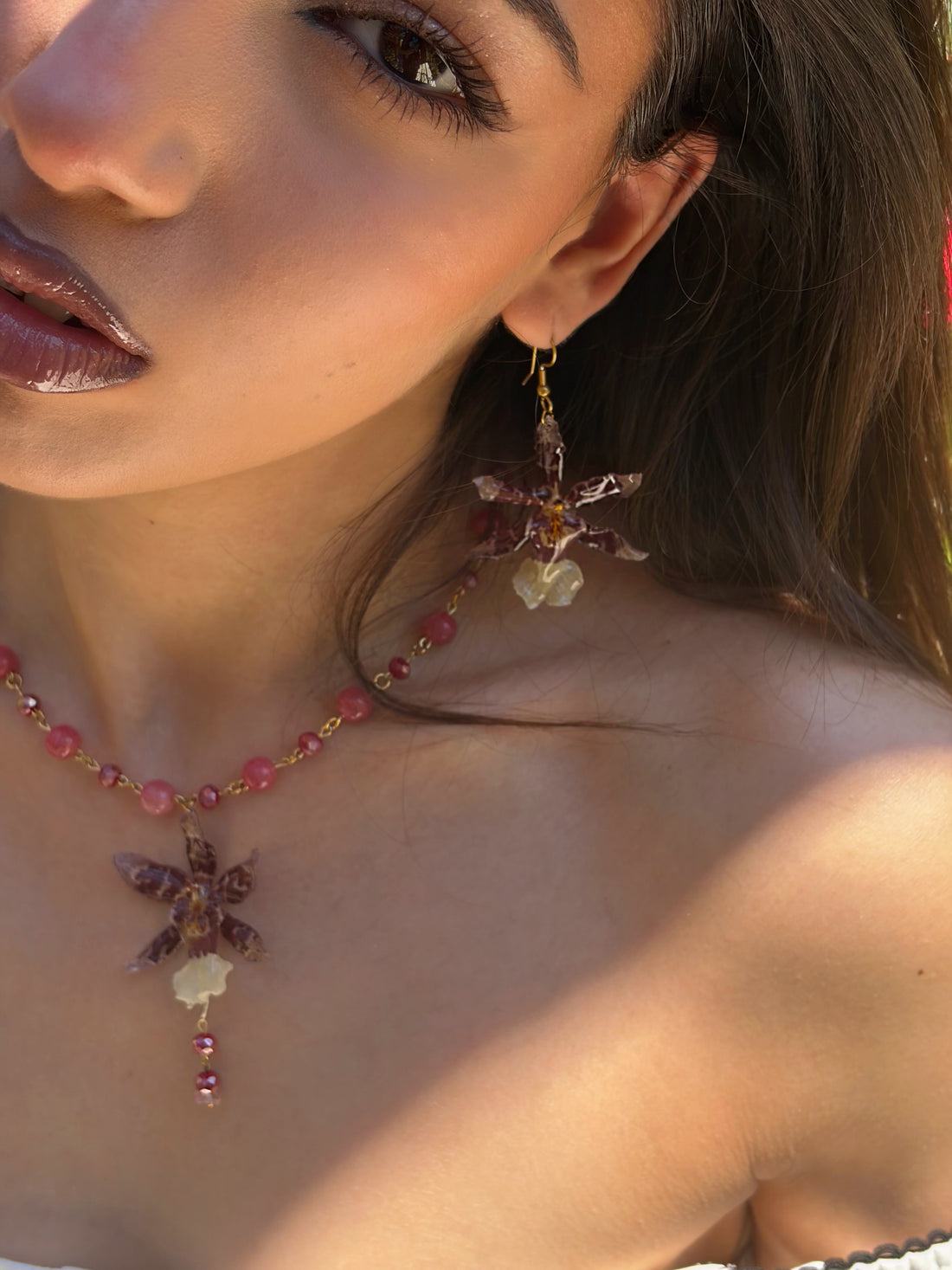 Necklace with pink beads and a star-shaped pendant worn by a person.